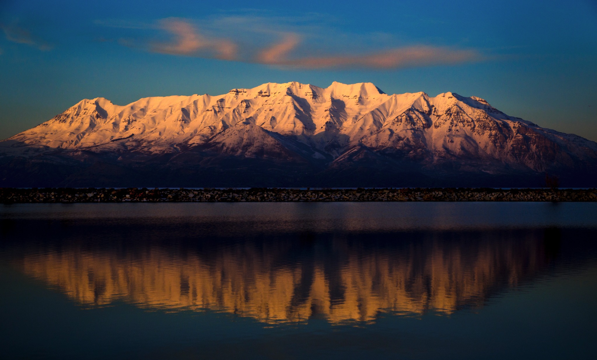 Snow-covered mountains reflected in the lake at sunset